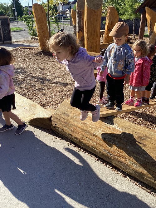 children jumping from logs