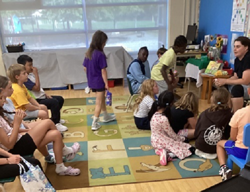 Children sitting on the carpet listening to the educator talk