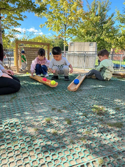 children putting balls down the ramp