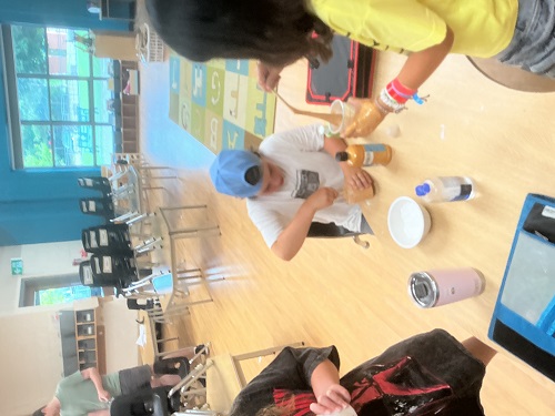 children sitting at a table mixing slime