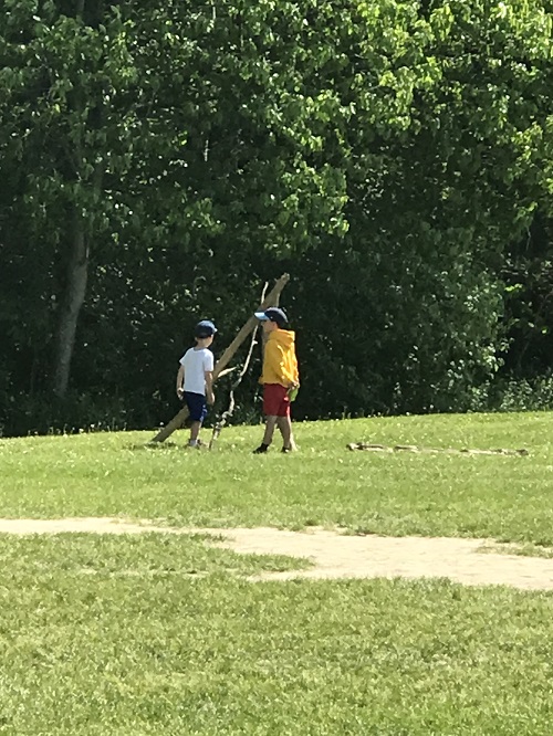 Children building with sticks out in the field.