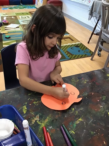 School aged child exploring with art materials